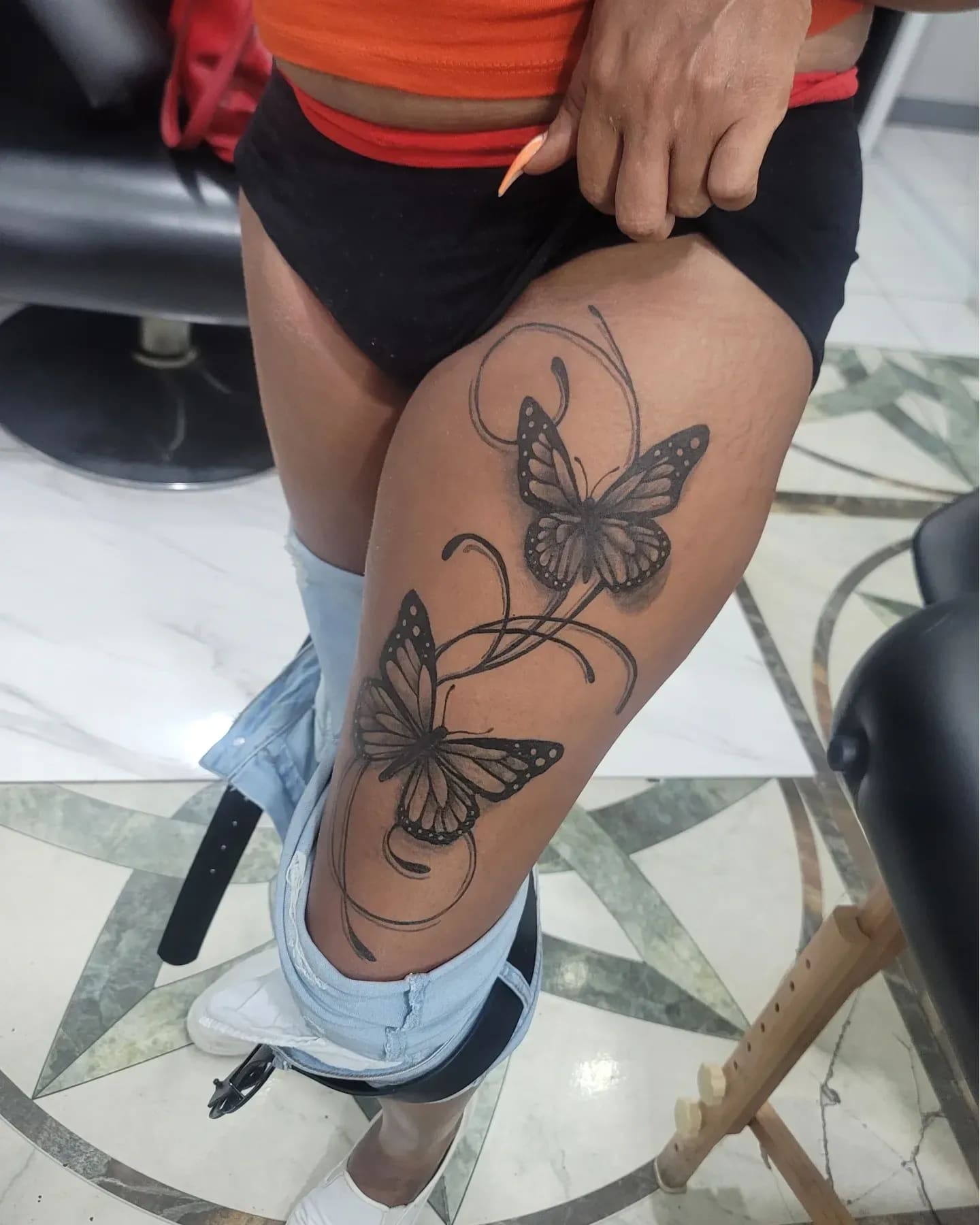 Black and grey Healed fine-line butterflies tattoo on the calf, by Soulraven Studios in Kingston, Jamaica