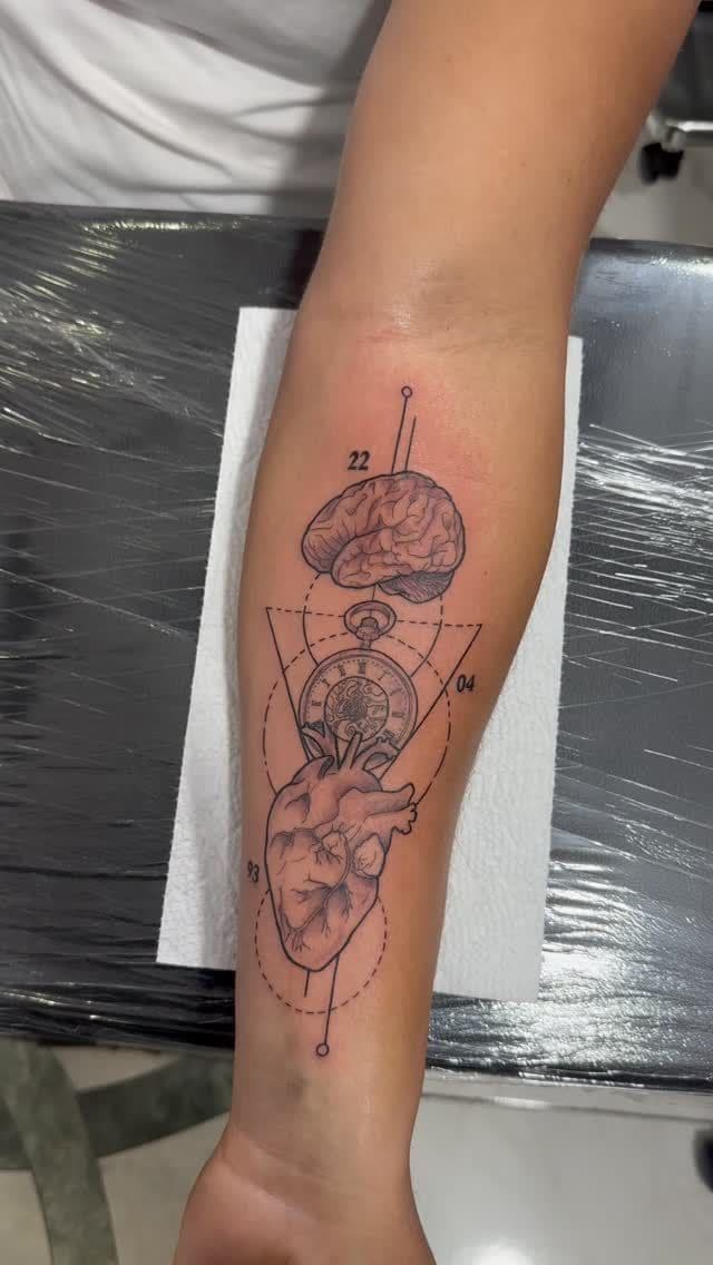 Black and grey Anatomical brain and heart with geometry tattoo on the forearm, by Soulraven Studios in Kingston, Jamaica