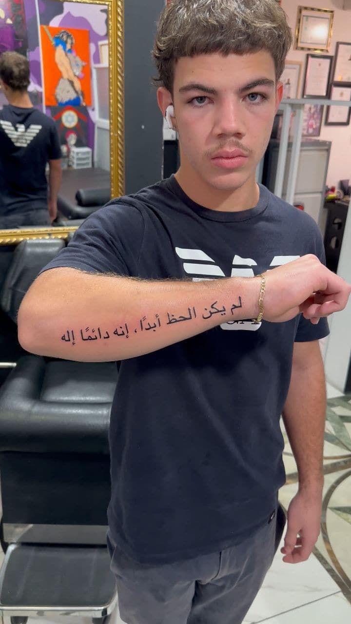 Black and grey Arabic script tattoo on the forearm, by Soulraven Studios in Kingston, Jamaica