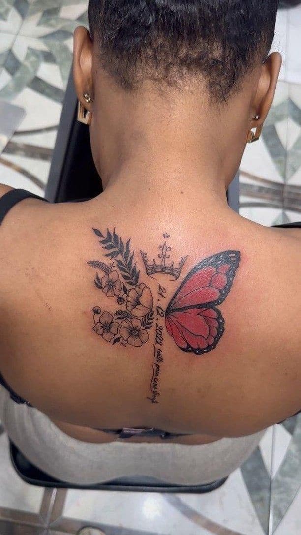 Black and grey with red Butterfly with flowers and script tattoo on the upper back, by Soulraven Studios in Kingston, Jamaica