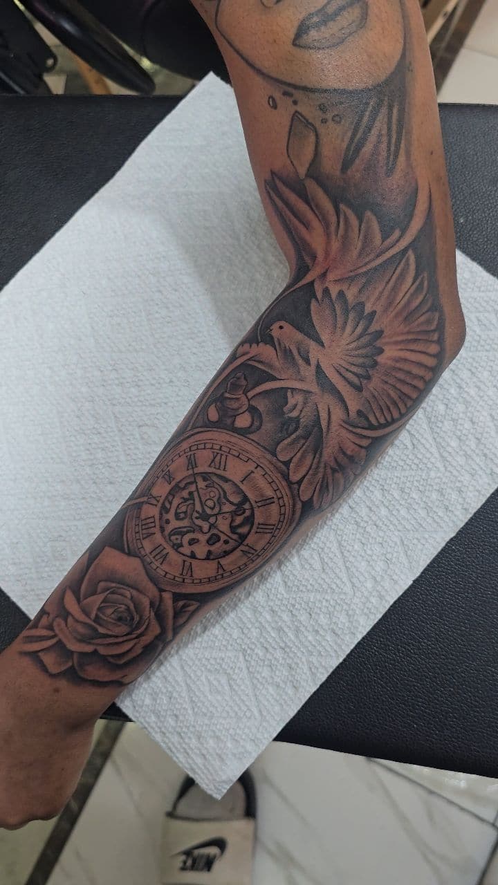 Black and grey Eagle, pocket watch, compass and rose sleeve tattoo on the full arm, by Soulraven Studios in Kingston, Jamaica