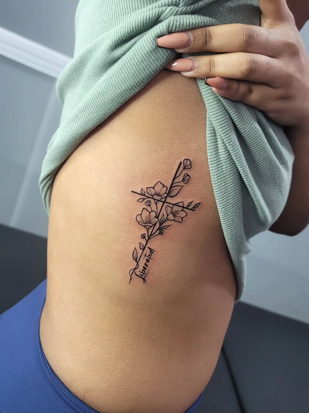 Black and grey Floral cross tattoo on the ribs, by Soulraven Studios in Kingston, Jamaica