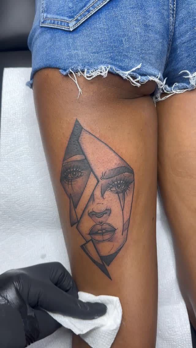 Black and grey Geometric split portrait tattoo on the calf, by Soulraven Studios in Kingston, Jamaica