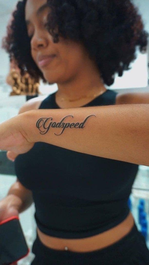 Black and grey “Godspeed” in script tattoo on the forearm, by Soulraven Studios in Kingston, Jamaica