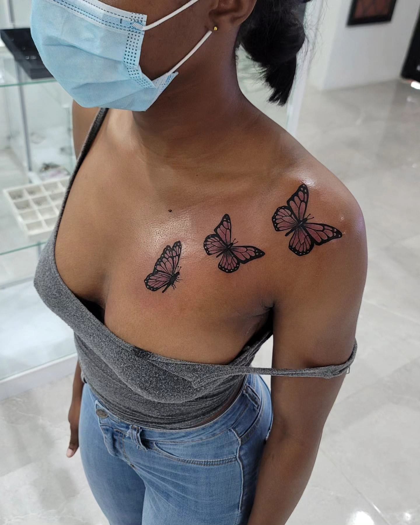 Black and grey Three butterflies tattoo on the collarbone, by Soulraven Studios in Kingston, Jamaica