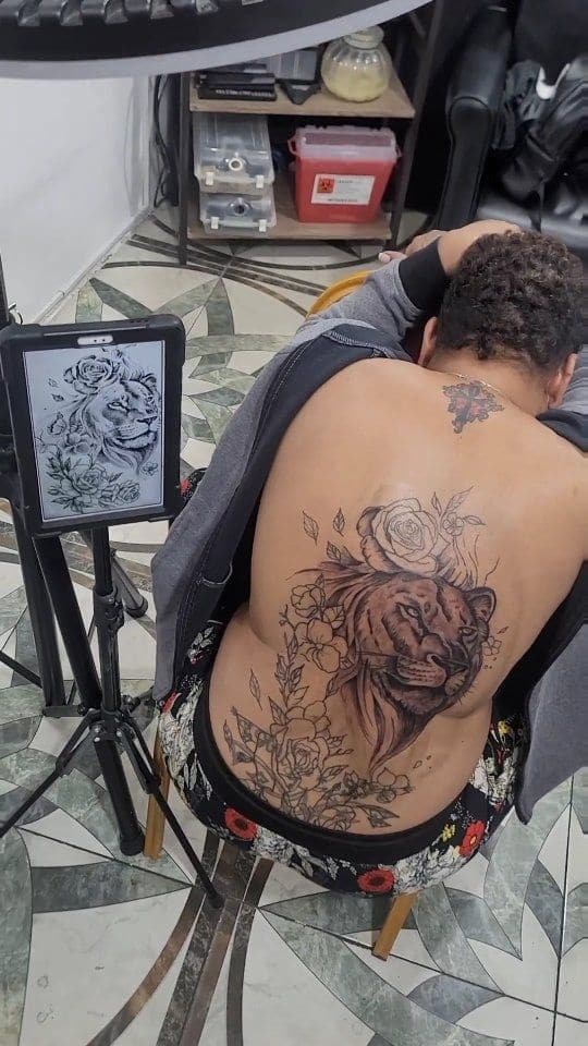 Black and grey Lion and rose cover-up tattoo on the back, by Soulraven Studios in Kingston, Jamaica