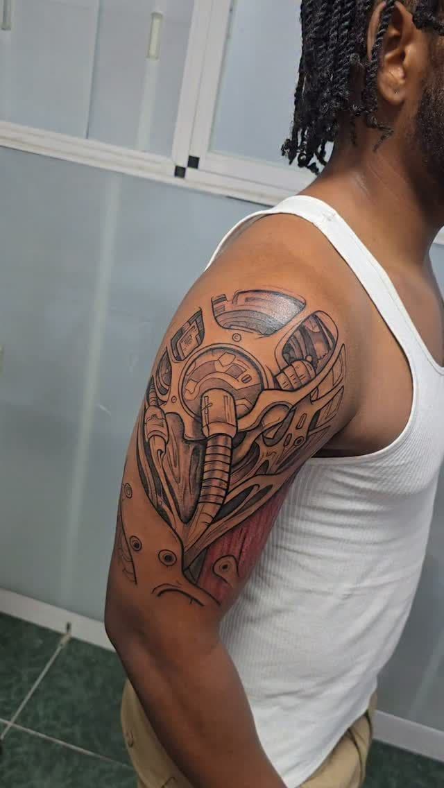 Black and grey Biomechanical sleeve in progress tattoo on the full arm, by Soulraven Studios in Kingston, Jamaica
