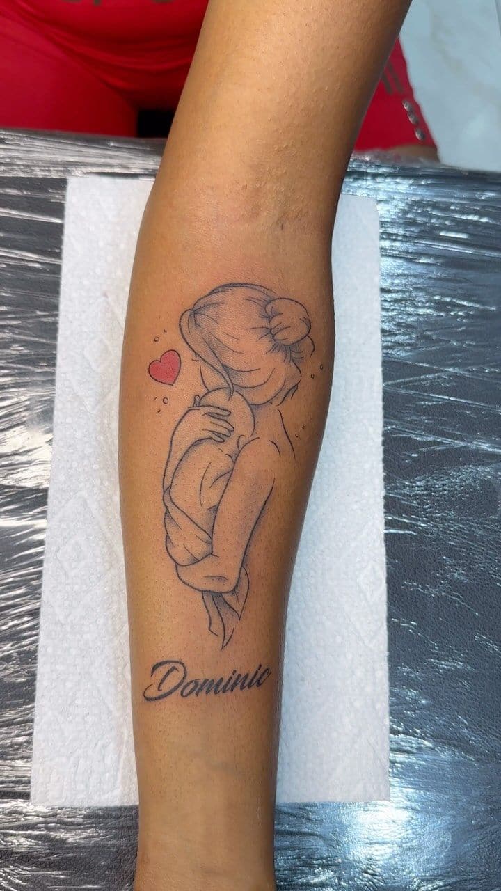 Black and grey Mother and child line art tattoo on the forearm, by Soulraven Studios in Kingston, Jamaica