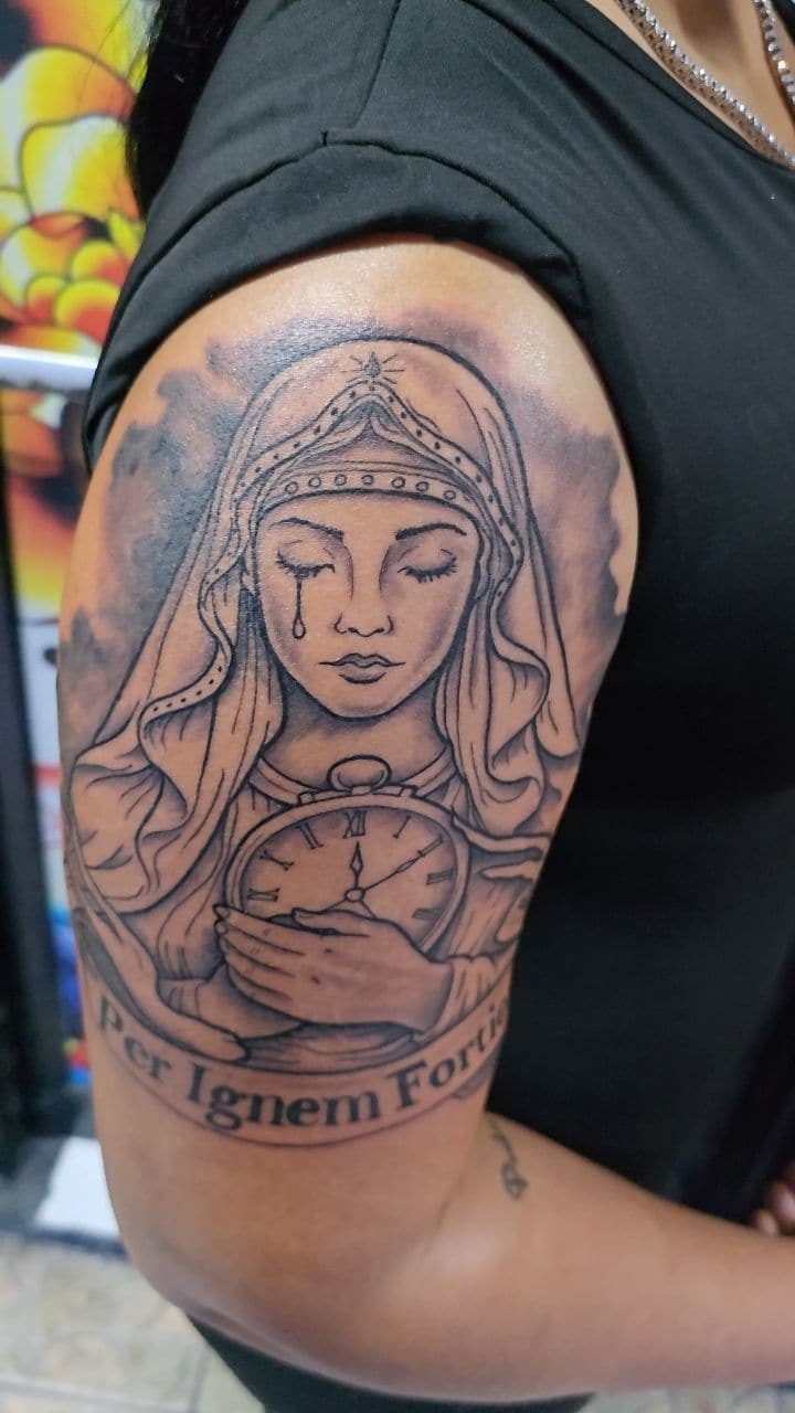 Black and grey Veiled Madonna holding a pocket watch tattoo on the upper arm, by Soulraven Studios in Kingston, Jamaica