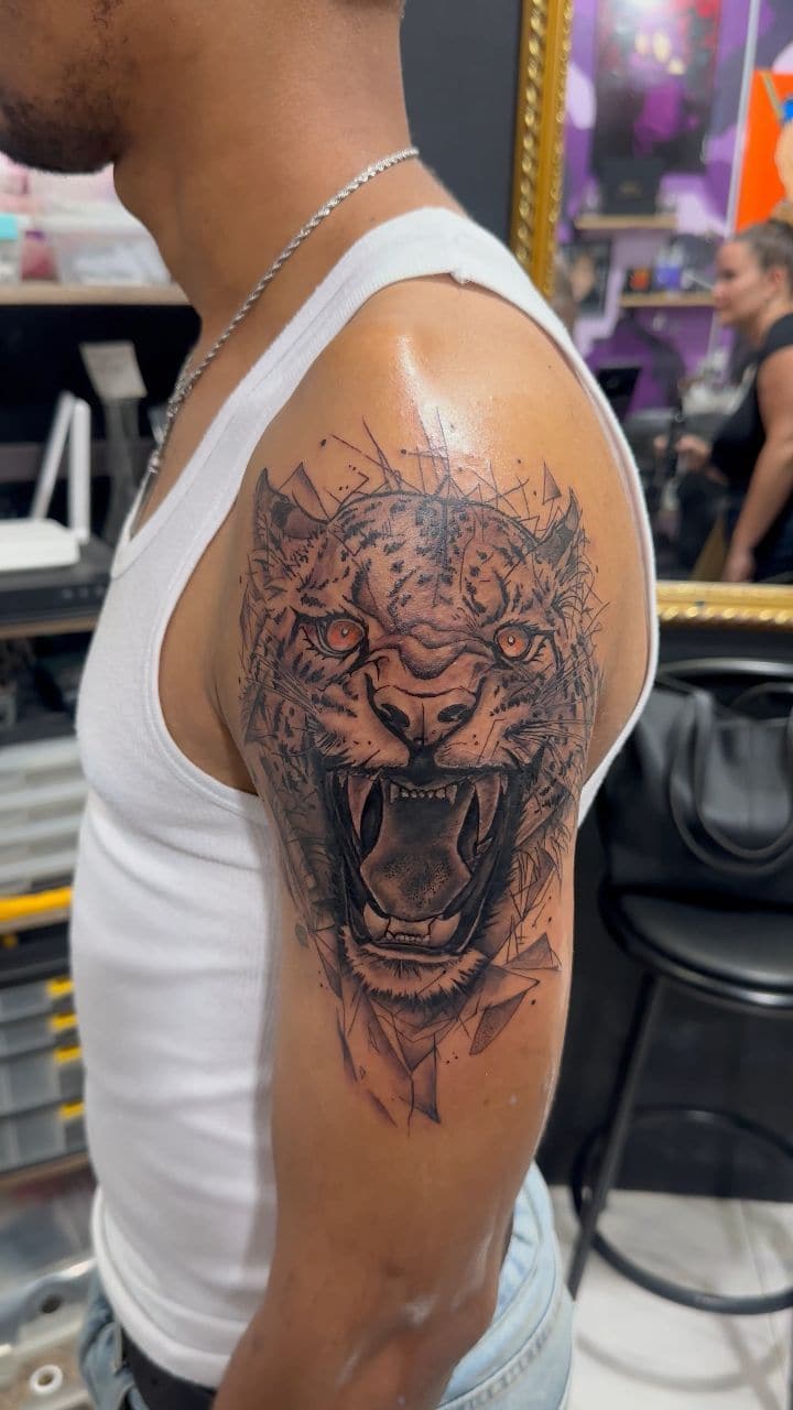 Black and grey Roaring tiger portrait tattoo on the shoulder, by Soulraven Studios in Kingston, Jamaica