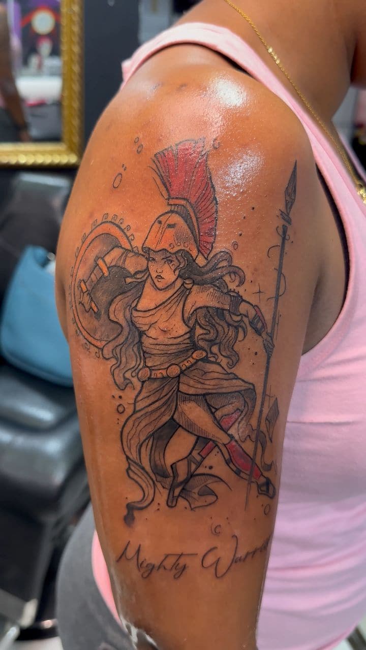 Black and grey Warrior goddess with spear tattoo on the upper arm, by Soulraven Studios in Kingston, Jamaica